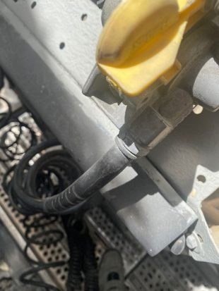 Yellow gladhand coupling and coiled cable at the trailer connection on the Actros