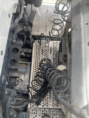 Coiled electrical and air lines routed across the tractor catwalk